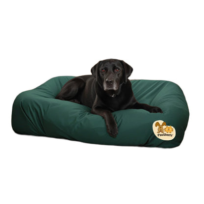 Black labrador retriever resting on a bolster style dog bed covered with a dark green PawSheets dog bed cover