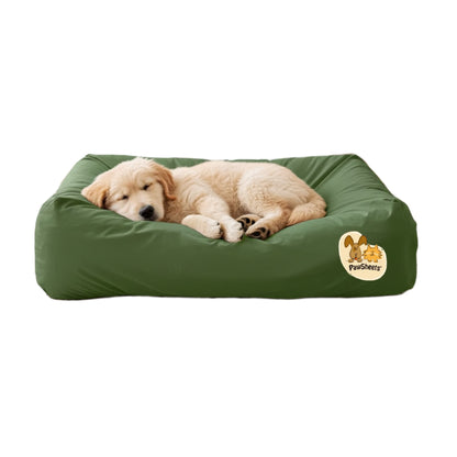Labrador retriever  puppy resting on a bolster style dog bed covered with an olive green PawSheets dog bed cover